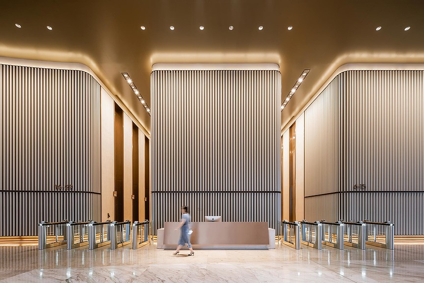 A person standing in a room with large wooden walls.
